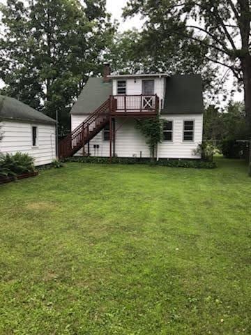1708 5th St, Menomonie, WI 54751 - rear view of property featuring a deck, a lawn, and stairs