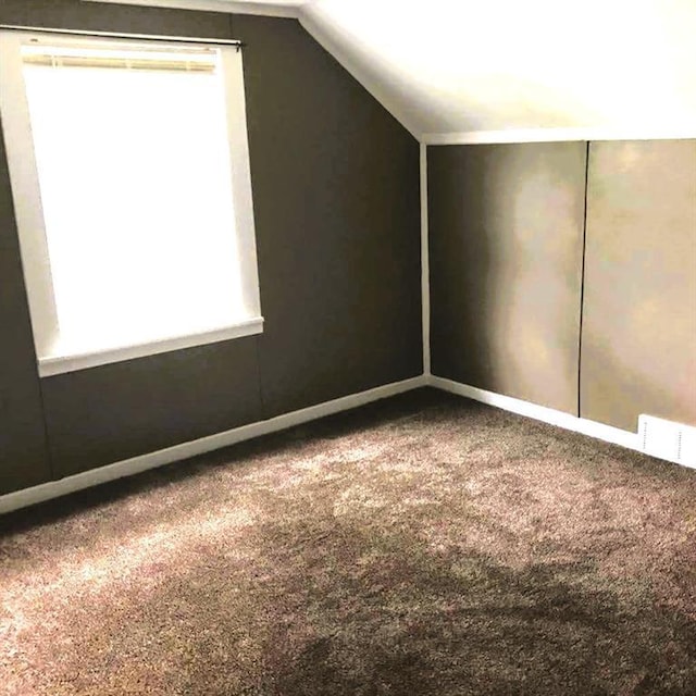 1708 5th St, Menomonie, WI 54751 - additional living space with carpet, visible vents, baseboards, and vaulted ceiling