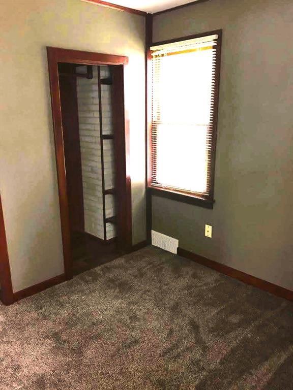 1708 5th St, Menomonie, WI 54751 - unfurnished bedroom with visible vents, baseboards, multiple windows, and carpet flooring