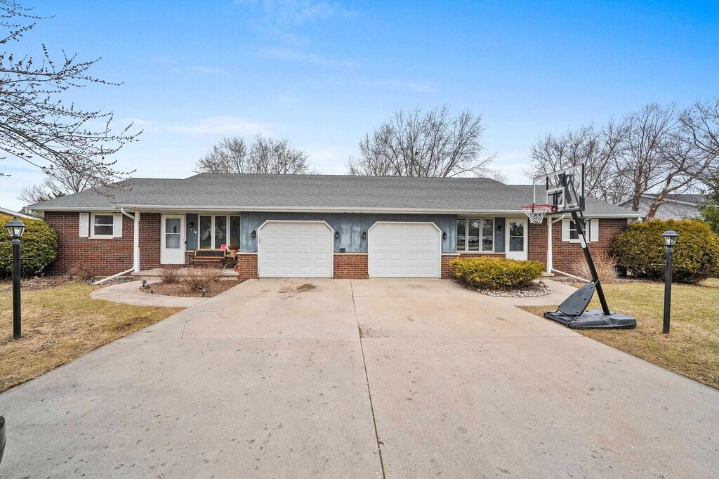 2467 Bluestone Pl, Green Bay, WI 54311 - ranch-style home with roof with shingles, a front lawn, brick siding, a garage, and driveway