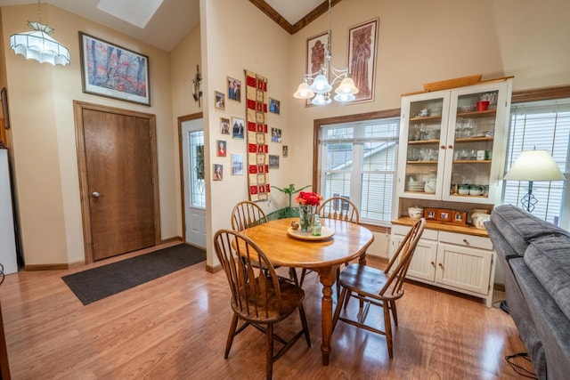421 Nature Haven Blvd Unit 15, Kewaskum, WI 53040 - dining area with light wood finished floors, an inviting chandelier, high vaulted ceiling, and baseboards