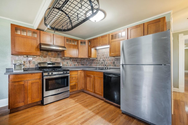 131 Madison Ave, Omro, WI 54963 - kitchen with crown molding, under cabinet range hood, decorative backsplash, stainless steel appliances, and light wood finished floors