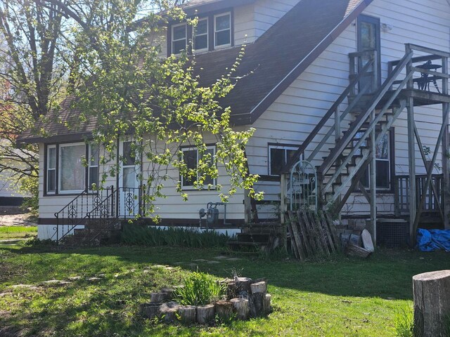 160 S Lemonweir St, Lyndon Station, WI 53944 - view of side of property featuring a lawn, stairs, and roof with shingles