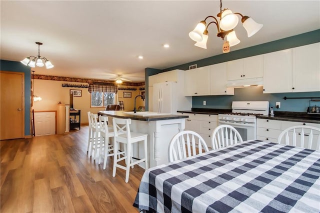 1229 W Beltline Rd, Spring Valley, WI 54767 - dining area featuring light wood-style flooring, recessed lighting, and ceiling fan with notable chandelier