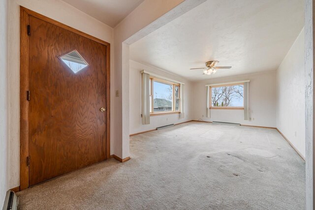 6671 Lasley Shore Dr, Winneconne, WI 54986 - foyer featuring light carpet, baseboards, a ceiling fan, and a baseboard heating unit