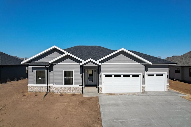 2025 Mulberry St, Sauk City, WI 53583 - view of front of property with an attached garage, roof with shingles, driveway, and stone siding