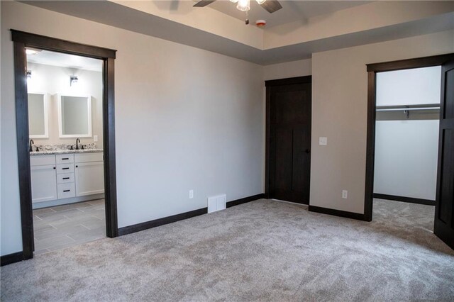 17297 109th Ave, Chippewa Falls, WI 54729 - unfurnished bedroom with light colored carpet, visible vents, a sink, a walk in closet, and baseboards