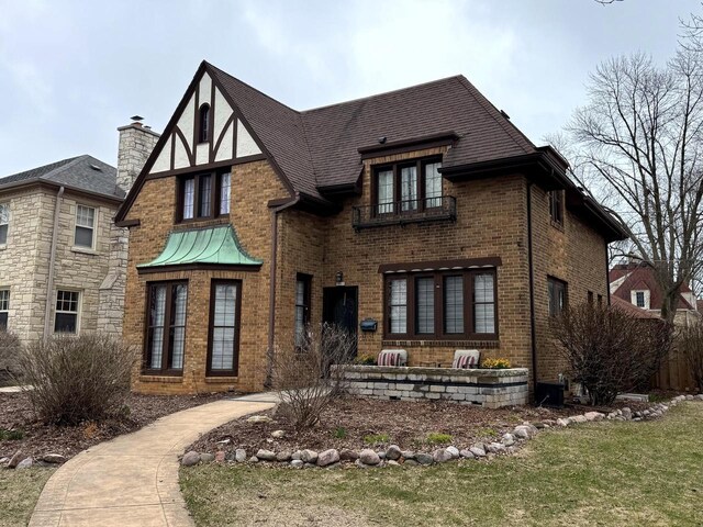 view of front of house featuring a chimney and brick siding