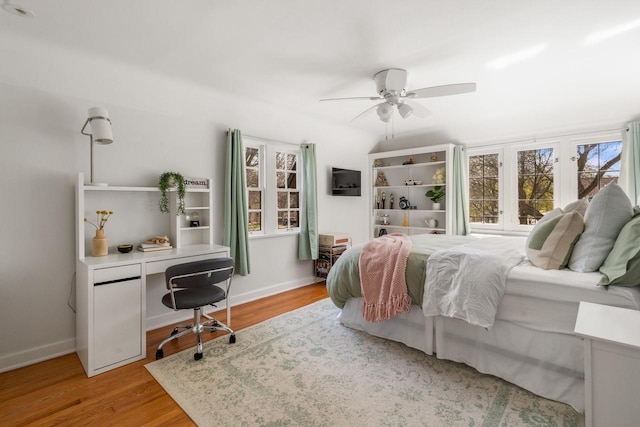 bedroom featuring baseboards, ceiling fan, and wood finished floors