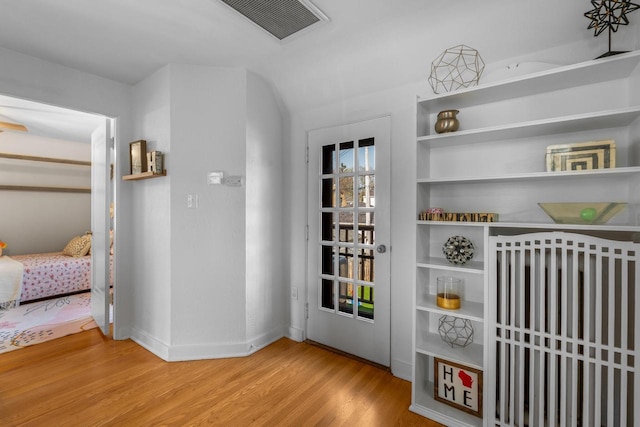 entryway featuring baseboards, wood finished floors, and visible vents