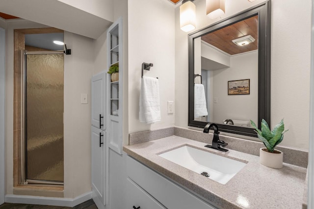bathroom featuring a shower stall and vanity