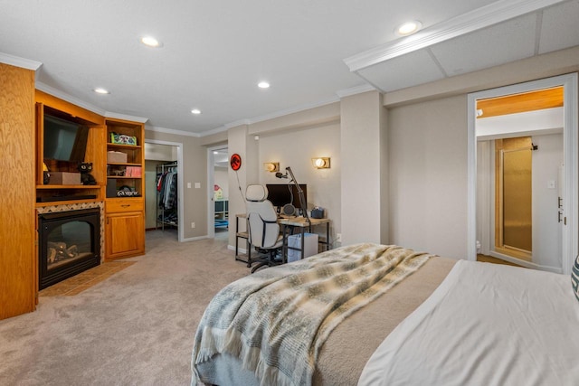 bedroom featuring light carpet, a walk in closet, a fireplace, recessed lighting, and ornamental molding
