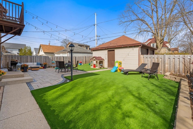 view of yard with a fenced backyard, an outbuilding, a patio, and an outdoor living space