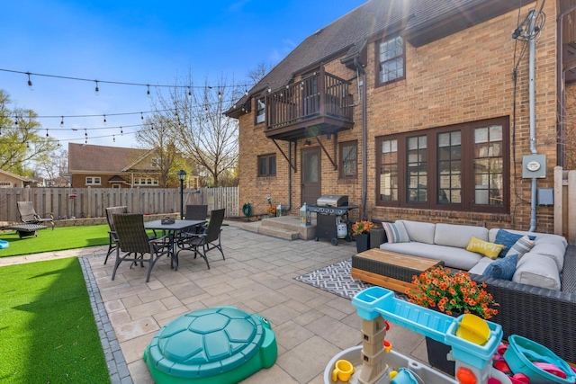view of patio with area for grilling, an outdoor living space, outdoor dining area, a balcony, and a fenced backyard