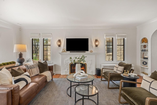living area featuring ornamental molding, a fireplace, and wood finished floors