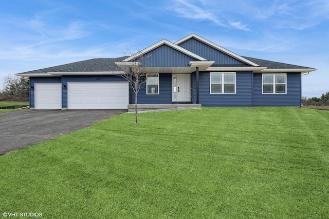 view of front facade featuring board and batten siding, driveway, a front yard, and a garage