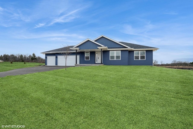 view of front of home featuring a garage, a front yard, and driveway