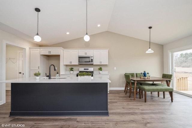 kitchen with a sink, light countertops, appliances with stainless steel finishes, and white cabinetry