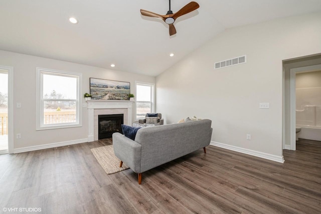 living room with visible vents, vaulted ceiling, a ceiling fan, and wood finished floors