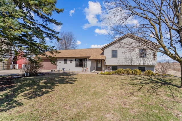 split level home with a front lawn, a garage, and driveway