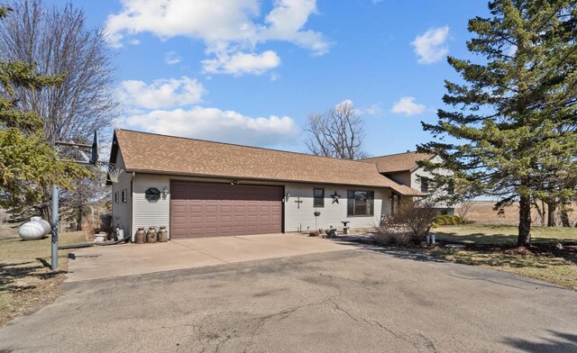 view of front of home featuring roof with shingles, a garage, and concrete driveway