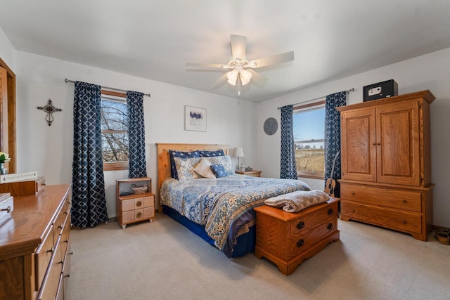 bedroom with light colored carpet and a ceiling fan