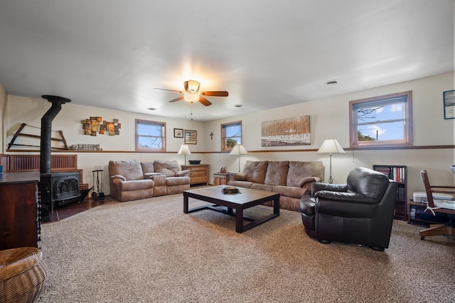living area featuring a wood stove and a ceiling fan