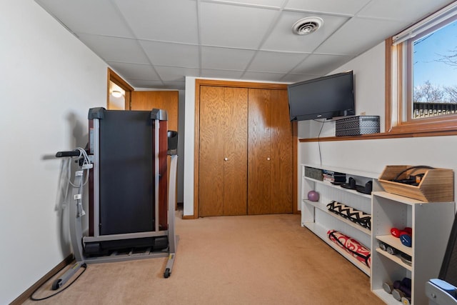 exercise room with visible vents, baseboards, a drop ceiling, and carpet floors