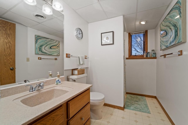 bathroom featuring vanity, baseboards, a paneled ceiling, tile patterned floors, and toilet