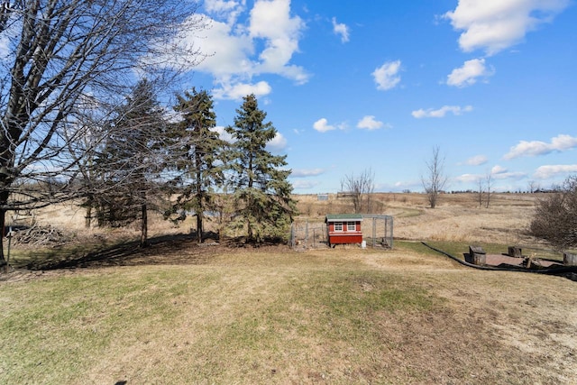 view of yard with a rural view and an outbuilding
