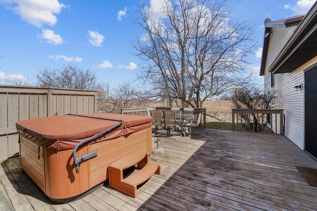wooden terrace featuring outdoor dining space and a hot tub