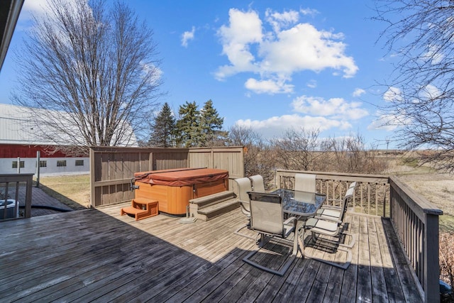 wooden terrace featuring outdoor dining area and a hot tub