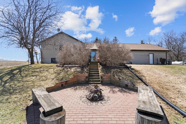 view of front of property featuring stairs, a patio, and a front yard