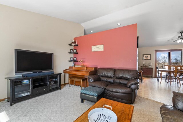 carpeted living room featuring baseboards, vaulted ceiling, and ceiling fan