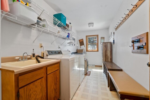 laundry area featuring washer and dryer, laundry area, a sink, and light floors