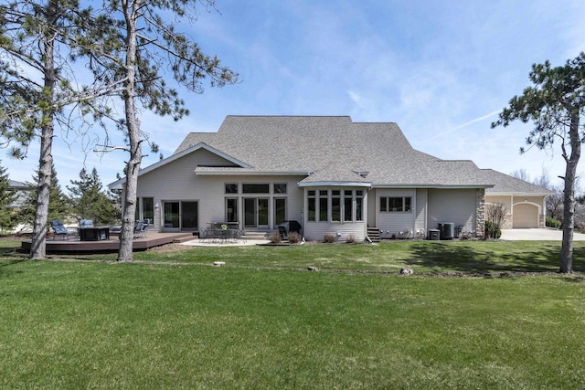 1105 Meadow Mist Rd, Middleton, WI 53562 - rear view of property with a yard, a shingled roof, a wooden deck, cooling unit, and an attached garage
