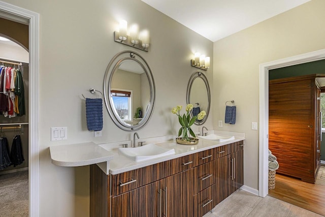 1105 Meadow Mist Rd, Middleton, WI 53562 - bathroom featuring double vanity, a sink, baseboards, and a spacious closet