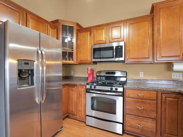 1734 Parkstone Ter Unit 73, Mount Pleasant, WI 53406 - kitchen featuring light wood-style flooring, brown cabinets, glass insert cabinets, and stainless steel appliances