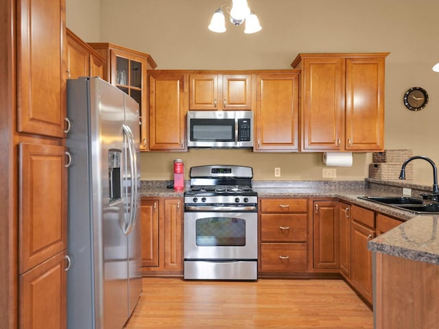 1734 Parkstone Ter Unit 73, Mount Pleasant, WI 53406 - kitchen with glass insert cabinets, light wood-style flooring, brown cabinetry, appliances with stainless steel finishes, and a sink