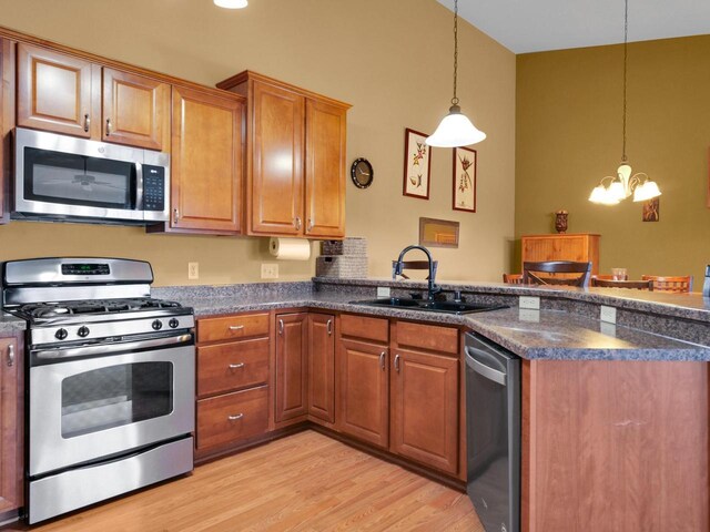 1734 Parkstone Ter Unit 73, Mount Pleasant, WI 53406 - kitchen featuring light wood-style flooring, a peninsula, a chandelier, appliances with stainless steel finishes, and a sink