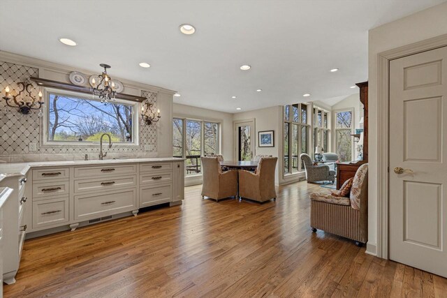 living room featuring recessed lighting, light wood-style flooring, and a notable chandelier
