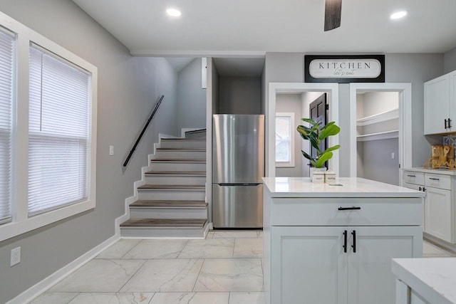 kitchen featuring light countertops, white cabinets, and freestanding refrigerator