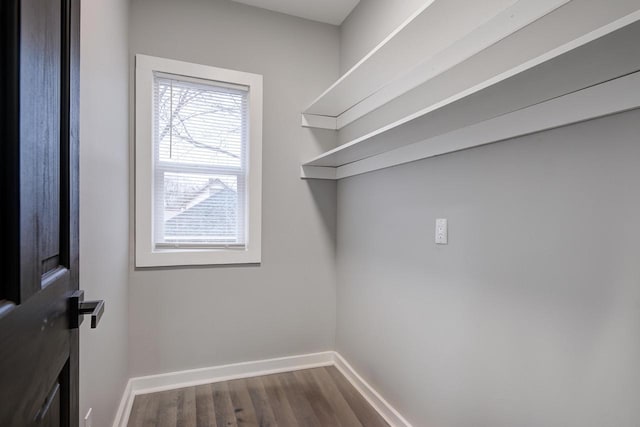 clothes washing area with baseboards and dark wood-style floors
