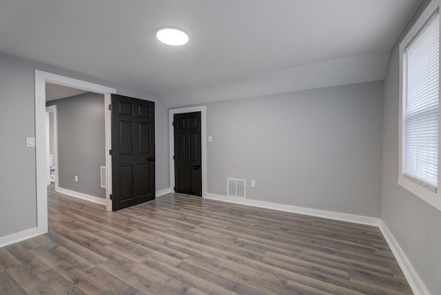 spare room with visible vents, baseboards, and wood finished floors