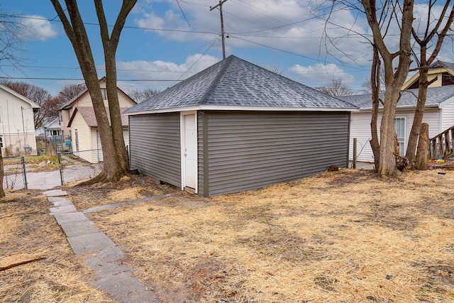 view of outdoor structure featuring fence and an outbuilding