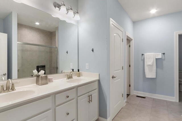 full bathroom featuring a shower stall, double vanity, visible vents, and a sink
