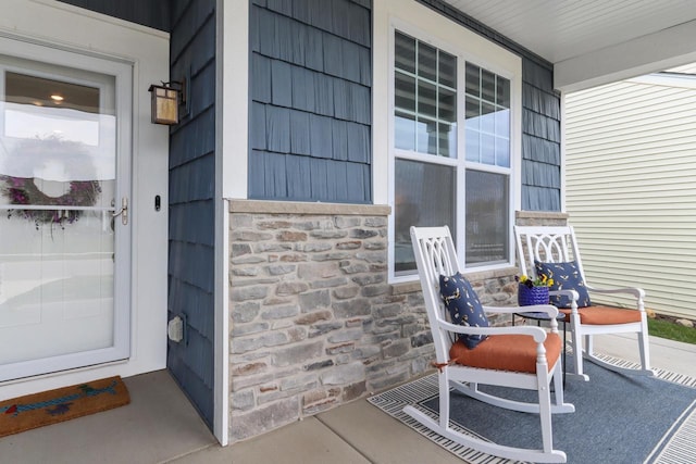exterior space with a porch and stone siding