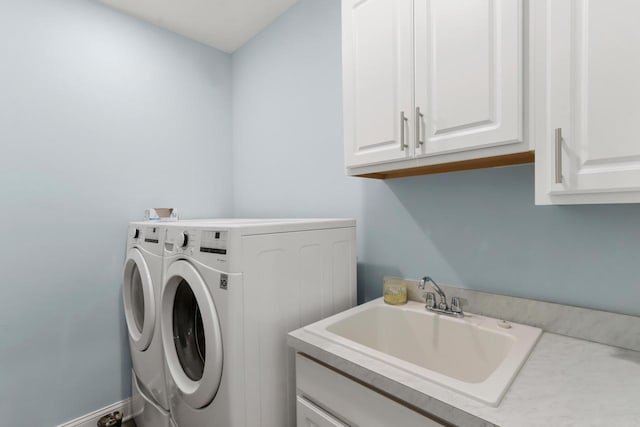 laundry area with cabinet space, washing machine and clothes dryer, and a sink