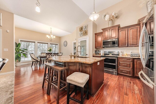 W209N11385 Reger Ct, Germantown, WI 53022 - kitchen with high vaulted ceiling, light stone countertops, dark wood finished floors, and appliances with stainless steel finishes