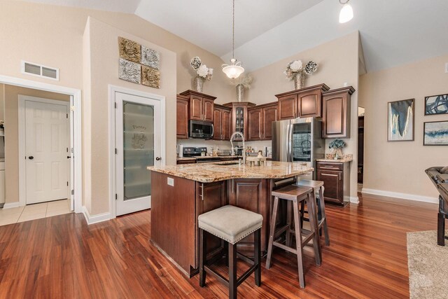 W209N11385 Reger Ct, Germantown, WI 53022 - kitchen with visible vents, high vaulted ceiling, appliances with stainless steel finishes, and baseboards